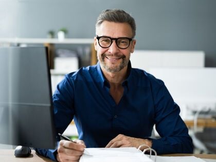 Smiling Man on His Desk